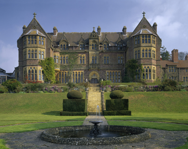 The south front of Knightshayes Court, with an imposing flight of steps leading up to the entrance (photo)