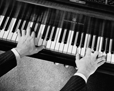 High angle view of a man's hands playing the piano