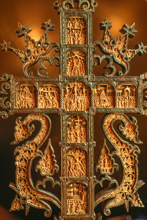 A small cross is intricately carved with religious scenes. Rila, Bulgaria., 1980s (photo)