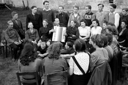 Priest Egon Voegler accompanying the yoith choir of Horka parish with his accordion, Germany 1949