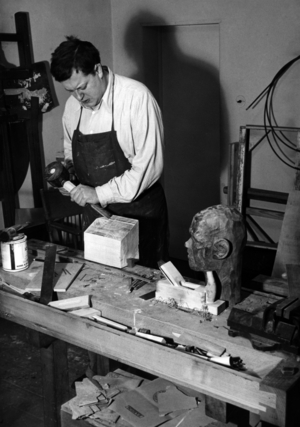Paul Dahlke works on a wood sculpture, 1939 (b/w photo)