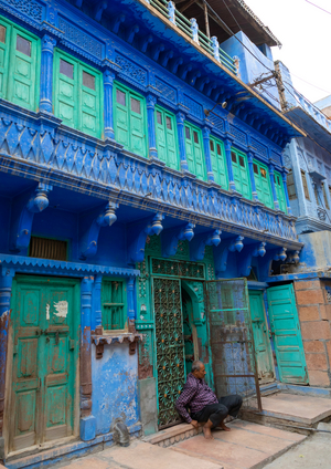 Indian man in front of an old blue house of a brahmin, Rajasthan, Jodhpur, India, 2019 (photo)