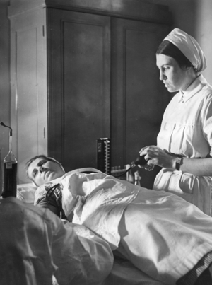 Red Cross nurse donating blood, 1940  (b/w photo)