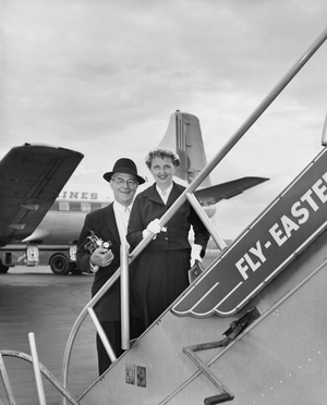 Senior couple standing on the staircase of an airplane