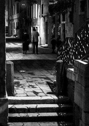 Two passers-by on a street at night, Venice, Italy (photo)