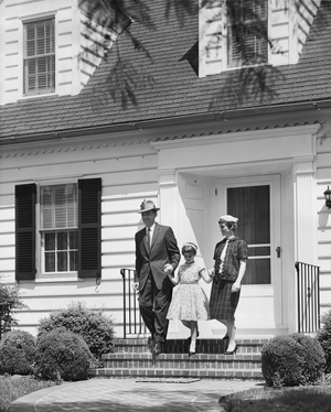 Family stepping out of their house