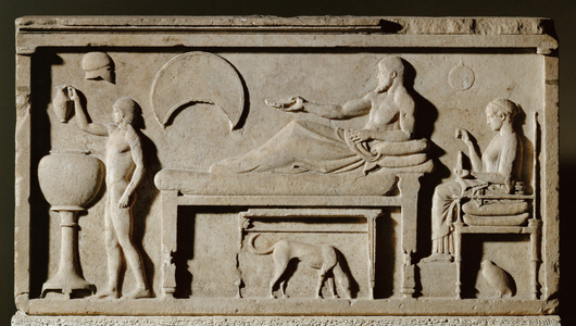 Funeral stele with a symposion scene: A man reclines on a bed holding a kylix, while a boy draws wine from a large vessel