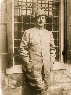 Giacomo Puccini in jacket, smoking cigarette (photo)