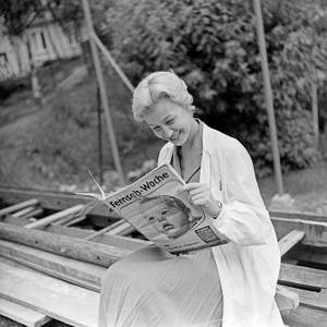 A woman reading the TV programm magazine "TV Fernseh Woche", Germany 1950s