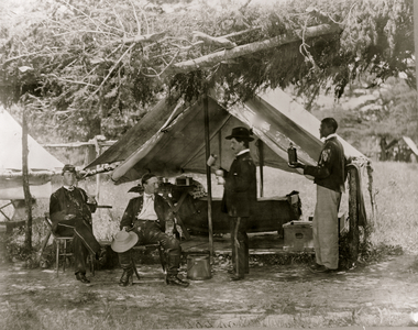Maj. H.H. Humphrey and others dining in front of their tent (photo)