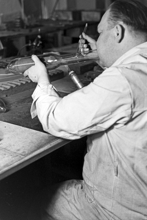 A staff member producing a fluorescent tube, Germany 1930s (b/w photo)