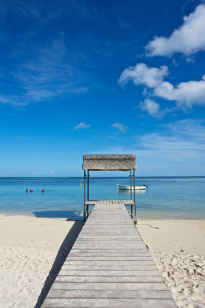 Wooden boardwalk over the white sand leading to the ocean, Mauritius (photo)