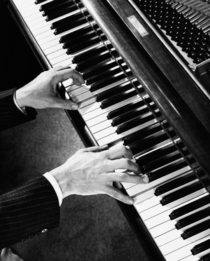 High angle view of a man's hands playing the piano