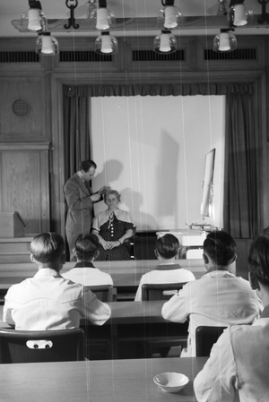 Male staff members at a lesson about hairdressing at Haus der Schoenheit beauty salon, Germany 1930s (b/w photo)