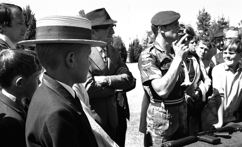Young boys and small crowd watching a Rhodesian Light Infantry demonstration, 1976 (b/w film still)