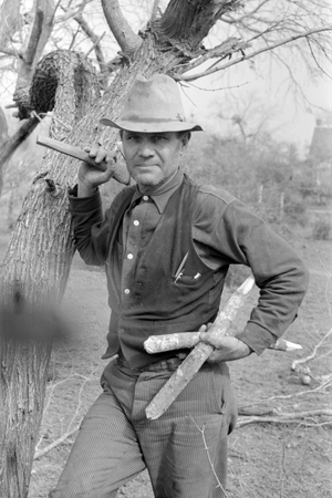 White migrant worker with hatchet and stakes to be used in setting up new camp near Harlingen, Texas, 1939 (photo)