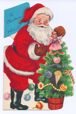 A die-cut Xmas Card of Father Christmas decorating a Christmas tree, his costume covered with red flocking, circa 1910 (coloured lithograph)