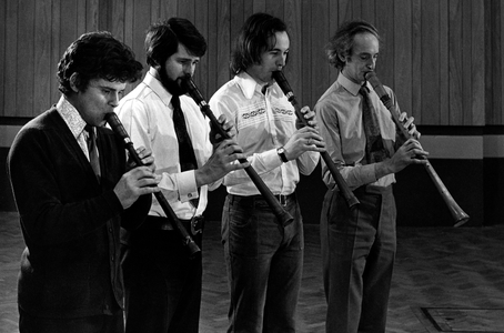 Four large renaissance recorders being played