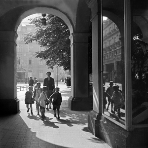 A kinergarten teacher strolling with her group of children through the inner city of Bad Ems, Germany 1930s (b/w photo)