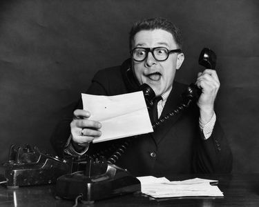 Close-up of a businessman using two telephones