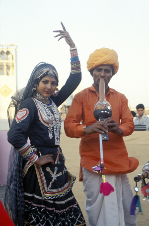 India.  Musician Playing An Instrument Called A Been And Dancer