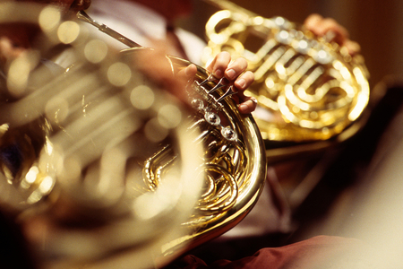 Horns in an orchestra - focusing on the hand of the musician