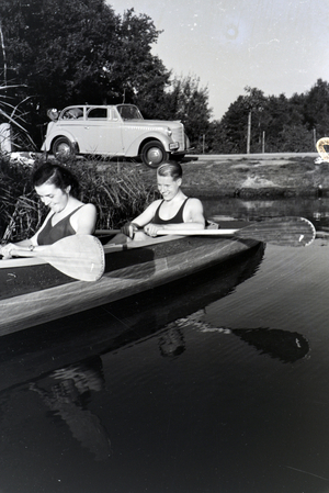 Young couple paddling in a boat on a lake near the river, Germany 1930s (b/w photo)