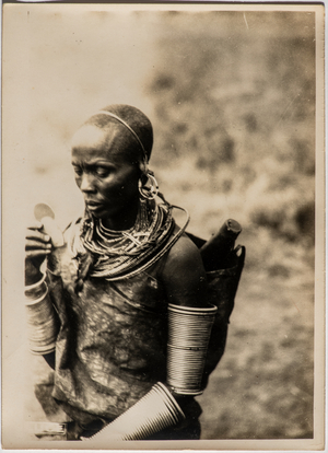 Portrait of a woman of the Masai tribe with ornaments on her ears, neck and arms and a saddlebag on her shoulders, 1930 (photo)
