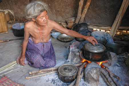 Cham culture: Elderly Cham woman cooking inside hut, village near Phan Rang, Vietnam.