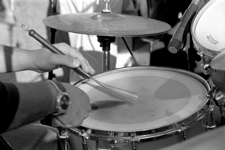 Close-up of drummer's hands playing a snare drum with brushes