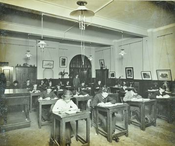Classroom of William Street School, Hammersmith with men and women at their desks, London, 1913 (b/w photo)