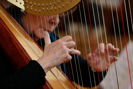 Woman playing a harp in church.  Saint-Nicolas de Veroce church. France. (photo)