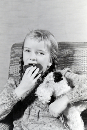A girl eating Liegnitzer Bomben, Germany 1930s (b/w photo)