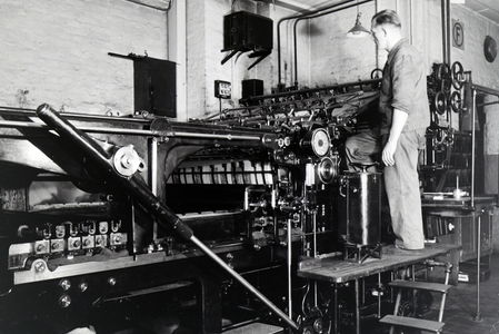 A worker controlling the rotary printing press in the plants of the mechanical engineering company MAN (Maschinenfabrik Augsburg-Nürnberg), Germany 1930s (b/w photo)