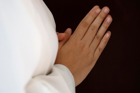 Altar boy praying, Close up on hands, Thi Nghe Church, Ho Chi Minh City, Vietnam, 2019 (photo)