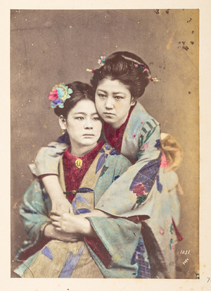 Japanese women in traditional dress, Three-quarter length portrait of two young woman, one seated, the other leaning over her shoulder with her arms around her,  Photographer: UnknownLucas Collection: Photographic record of the world tour of Charles James and Morton P,  Lucas, 1877-79, Dimensions: 145 mm x 103 mm