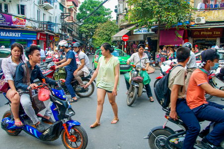 Vietnamese transport: Woman trying to cross a busy street in the Old Quarter, Hanoi, Vietnam