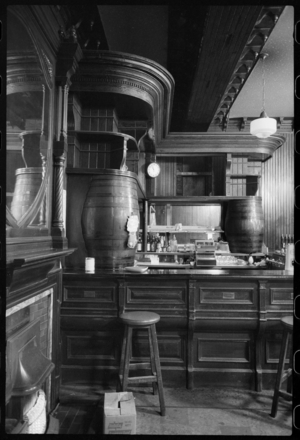 The interior of the Turks Head Hotel on Grey Street, showing a curved bar in the corner with barrels supporting the shelving at the back and some bar stools in the foreground, c.1955-c.1980 (b/w photo)