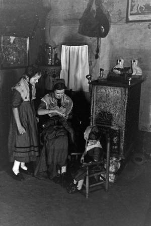 A woman sitting with two girls wearing traditional costume of Ammerland near Bad Zwischenahn at the Oldenburg area, Germany 1930s (b/w photo)