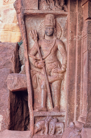 Bas relief of a Shiva guardian wielding Shiva's trident in Cave 1 of the Badami cave temples built in the late 6th Century A.D. by Pulekeshi I, Badami, Karnataka, India, 1992 (photo)