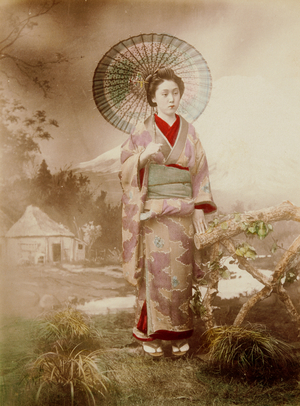 Woman in Photo Studio Against Backdrop Holding Umbrella, 1885-1900