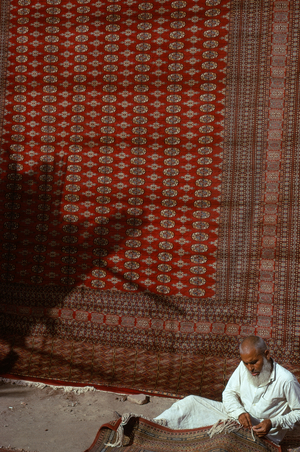 Man mending rug, Lahore, Pakistan, 1974 (photo)