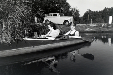 Young couple paddling in a boat on a lake near the river, Germany 1930s (b/w photo)