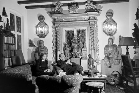 German actor Paul Wegener smoking a cigar while sitting in his living room with his wife, actress Greta Schroeder, at his house in Berlin, Germany 1930s (b/w photo)