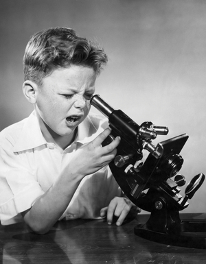 Schoolboy looking through microscope