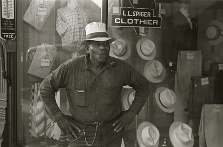 African American Resident of Plain City, Ohio smoking a pipe outside of a clothing store 1935 (photo)