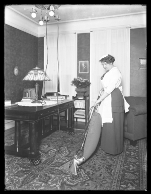 Unidentified woman demonstrating the use of the Apex vacuum cleaner, c.1913-14 (b/w photo)