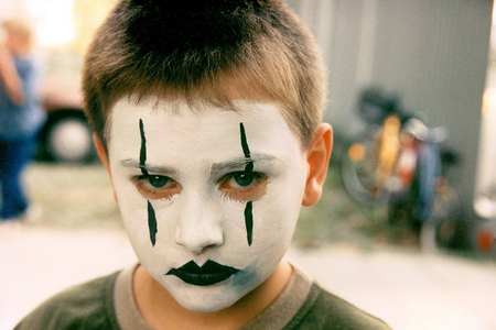 Child with painted clown mask, 1999 (photo)