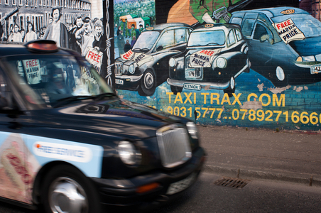 Belfast Black Taxi tours in front of one of the loyalist murals Falls road street, Belfast, Northern Ireland, UK (photo)