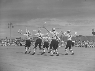 A view of a group of men that appear to be morris dancing, surrounding them is a large crowd, 1930s-60s (b/w photo)